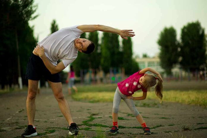 Man and young girl stretching outdoors