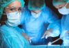surgeon in protective gear looking at camera during operation