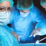 surgeon in protective gear looking at camera during operation