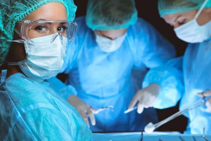 surgeon in protective gear looking at camera during operation
