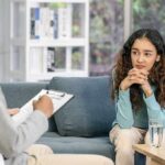 The Hidden Symptom Fueling Depression Young woman sitting on couch during counseling session