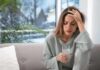 How does a painkiller really “know” where it hurts? Woman holding a glass of water with hand on forehead