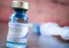 Fentanyl vial on a table with blurred syringe in background