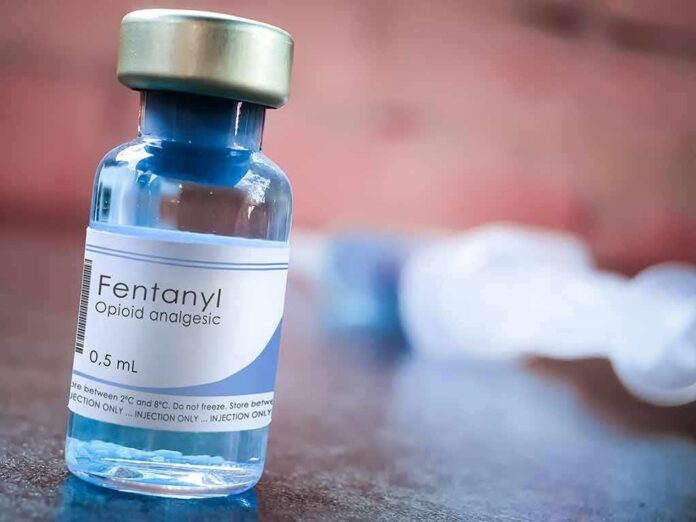 Fentanyl vial on a table with blurred syringe in background