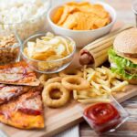 Fat or Fuel? What Your Body REALLY Does With Carbohydrates Assorted fast food on a wooden board