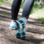 HYROX Surge Shreds Midlife Fitness Myth Runner's feet in athletic shoes on a forest trail