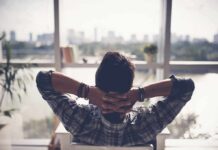 Person relaxing in chair facing large window