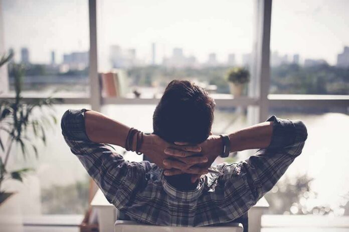 Person relaxing in chair facing large window
