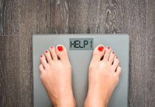 Feet on a digital bathroom scale displaying a help message