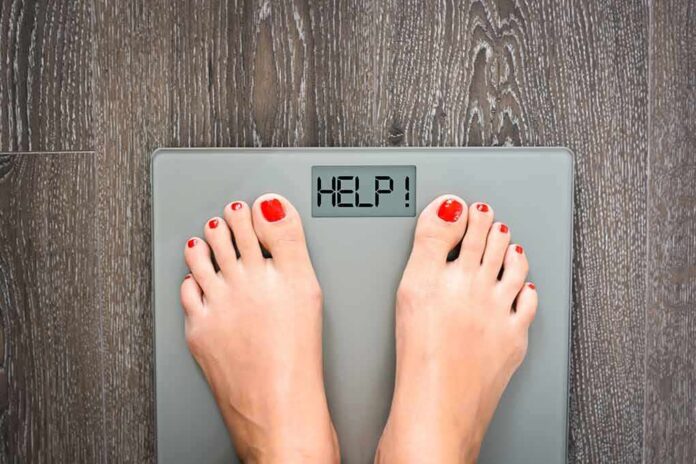 Feet on a digital bathroom scale displaying a help message