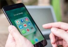 Hands holding a smartphone with social media apps on screen