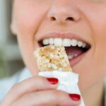 Protein Bars’ Hidden Heart Hit Person taking a bite of a granola bar