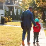 Man walking with child on sidewalk