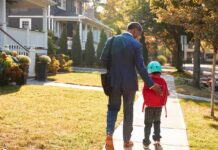 Man walking with child on sidewalk