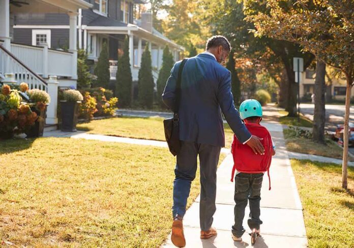 Man walking with child on sidewalk